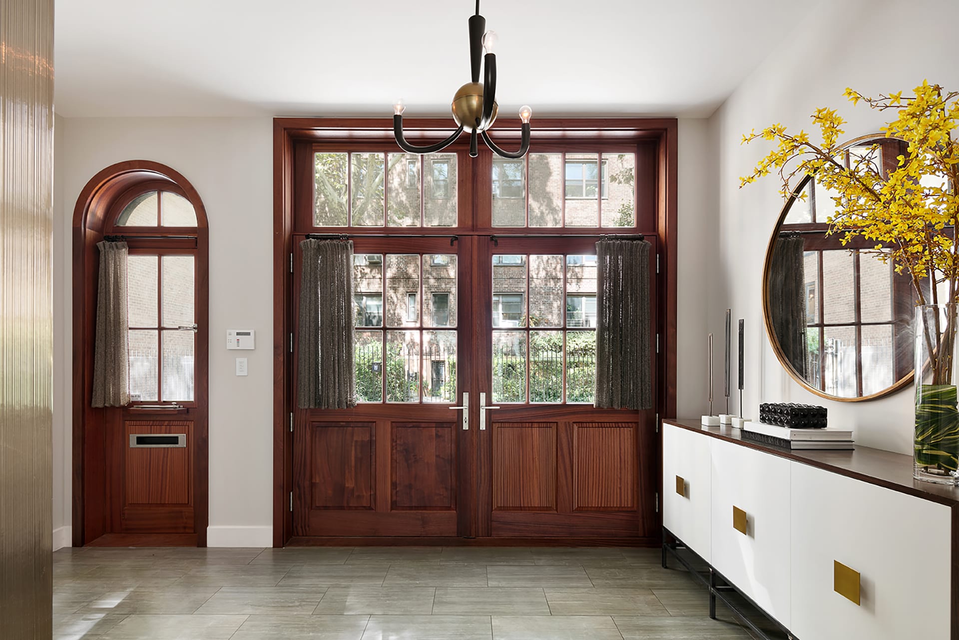 Entryway with stone pavers and custom wood doors in a Brooklyn Heights carriage house.
