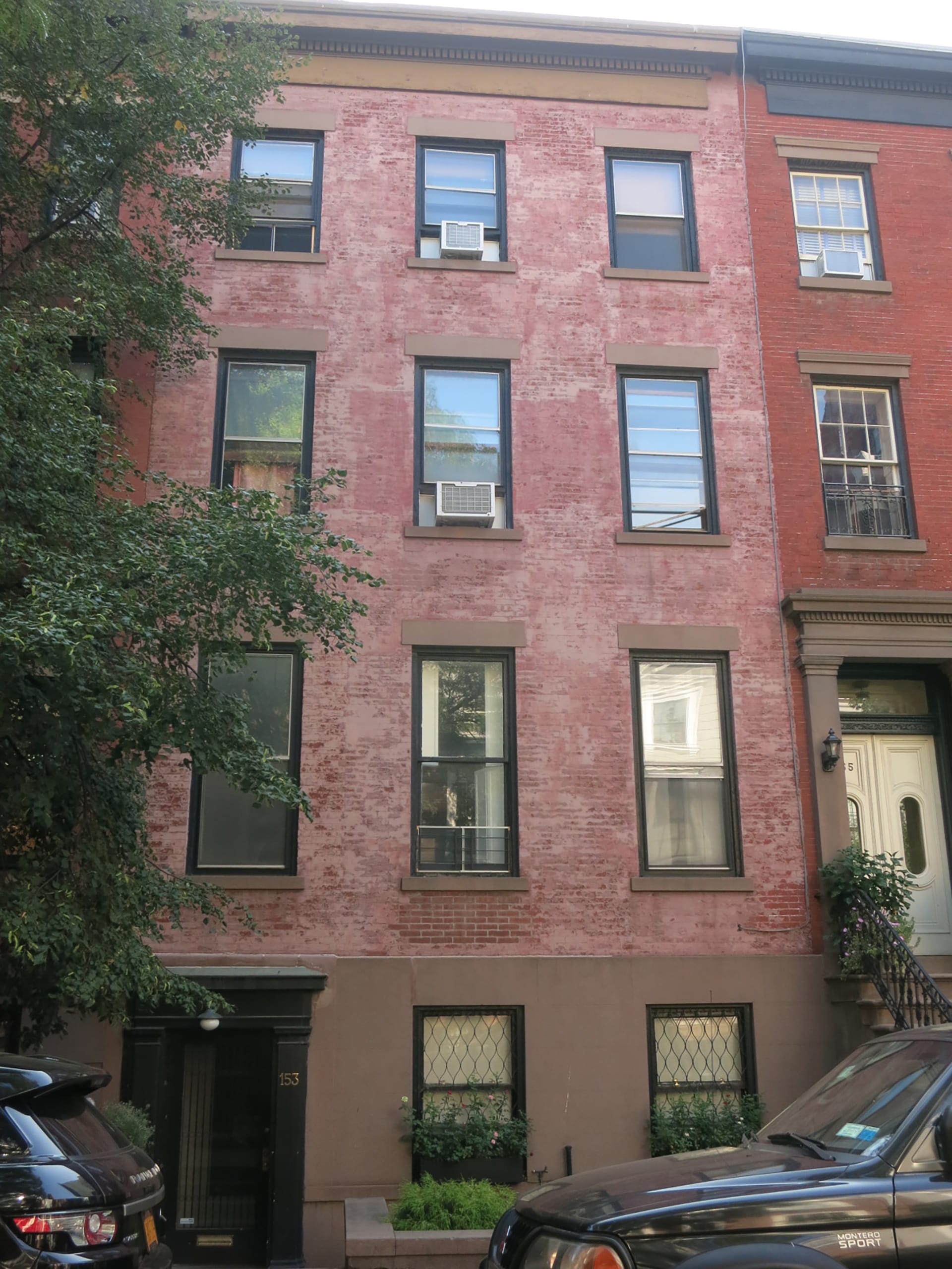 Front façade of a brick townhouse with brownstone lintels and details before our renovation