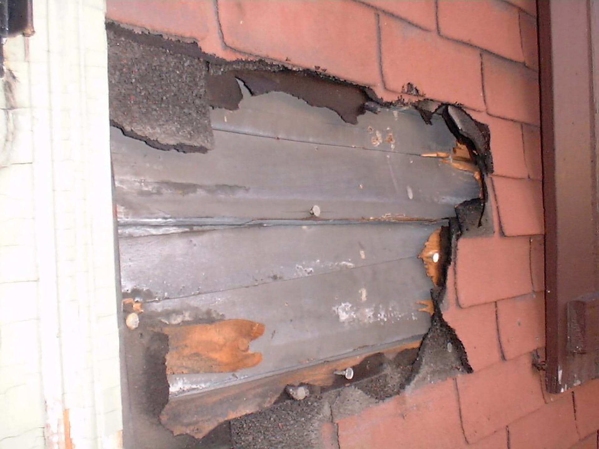 Original wood siding revealed under the faux brick siding on a Brooklyn Heights townhouse