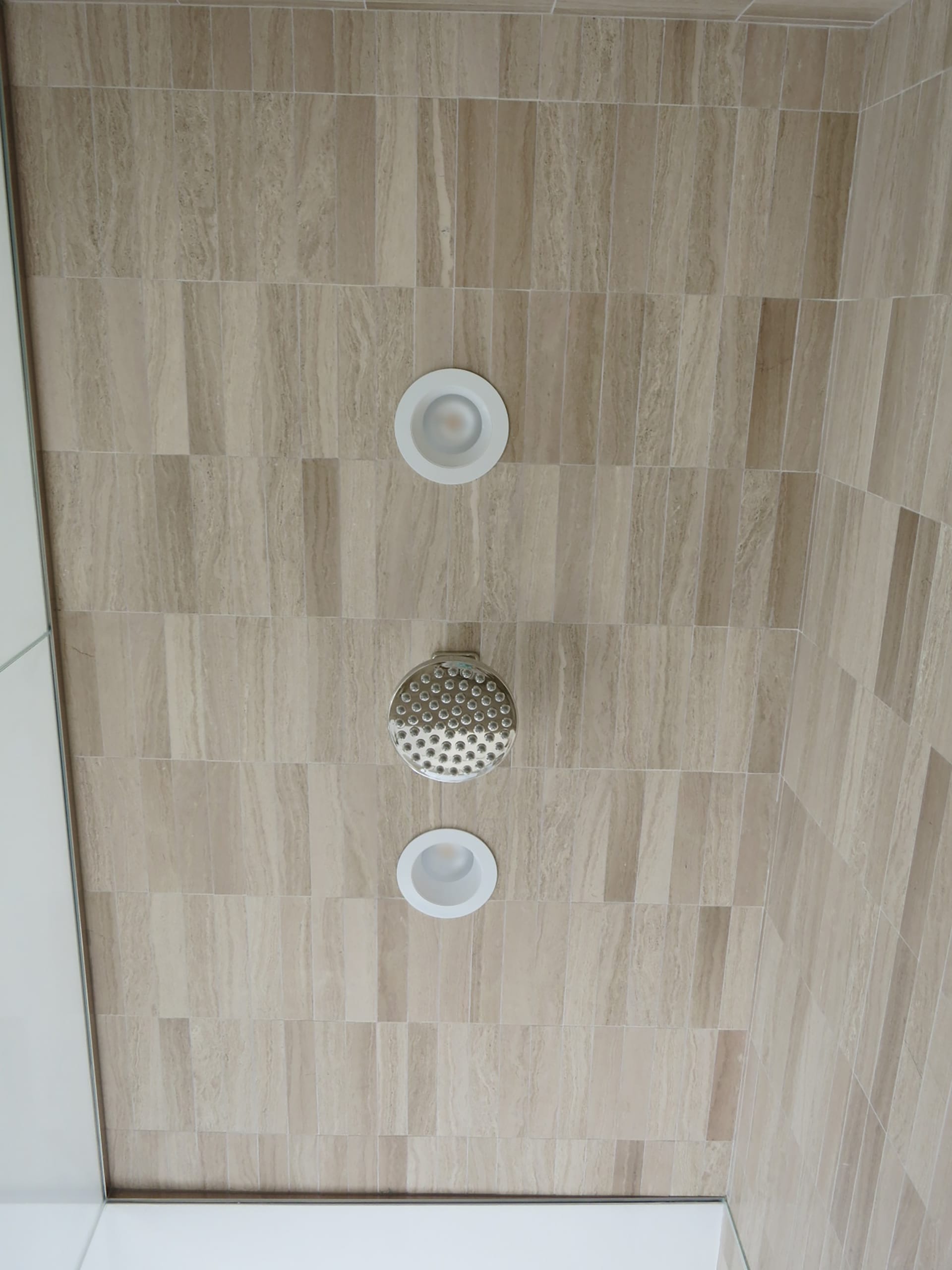Ceiling of a steam shower with recessed ceiling tiles.