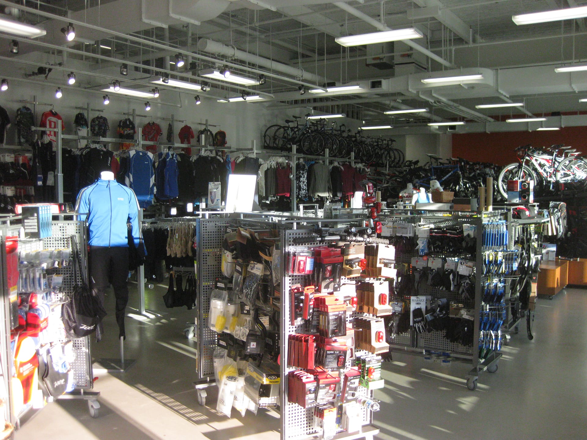 Racks of bike-related accessories and clothing in a bike shop.