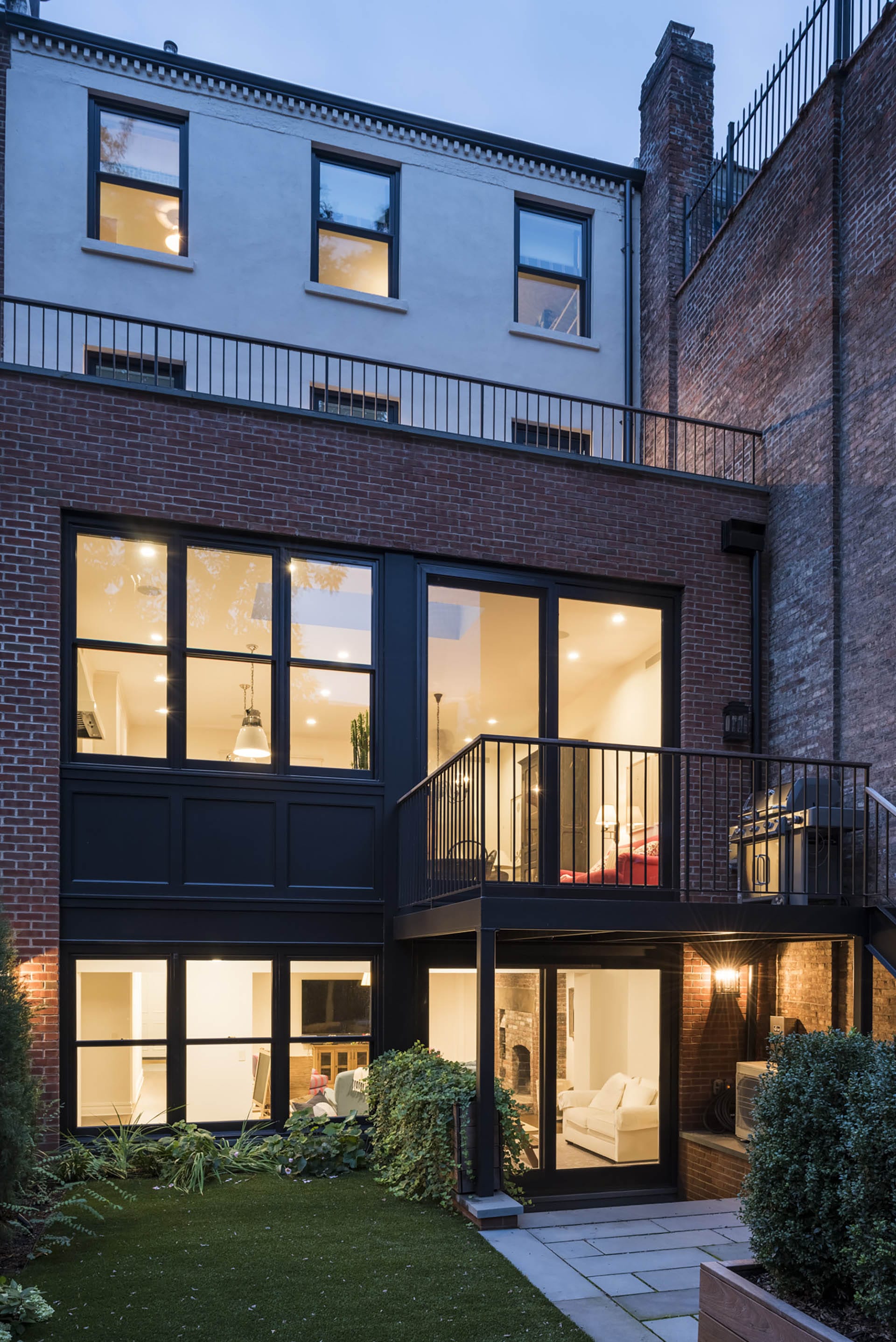 Rear façade of a Brooklyn Heights townhouse after our renovation, with a two-story brick extension and a new deck.