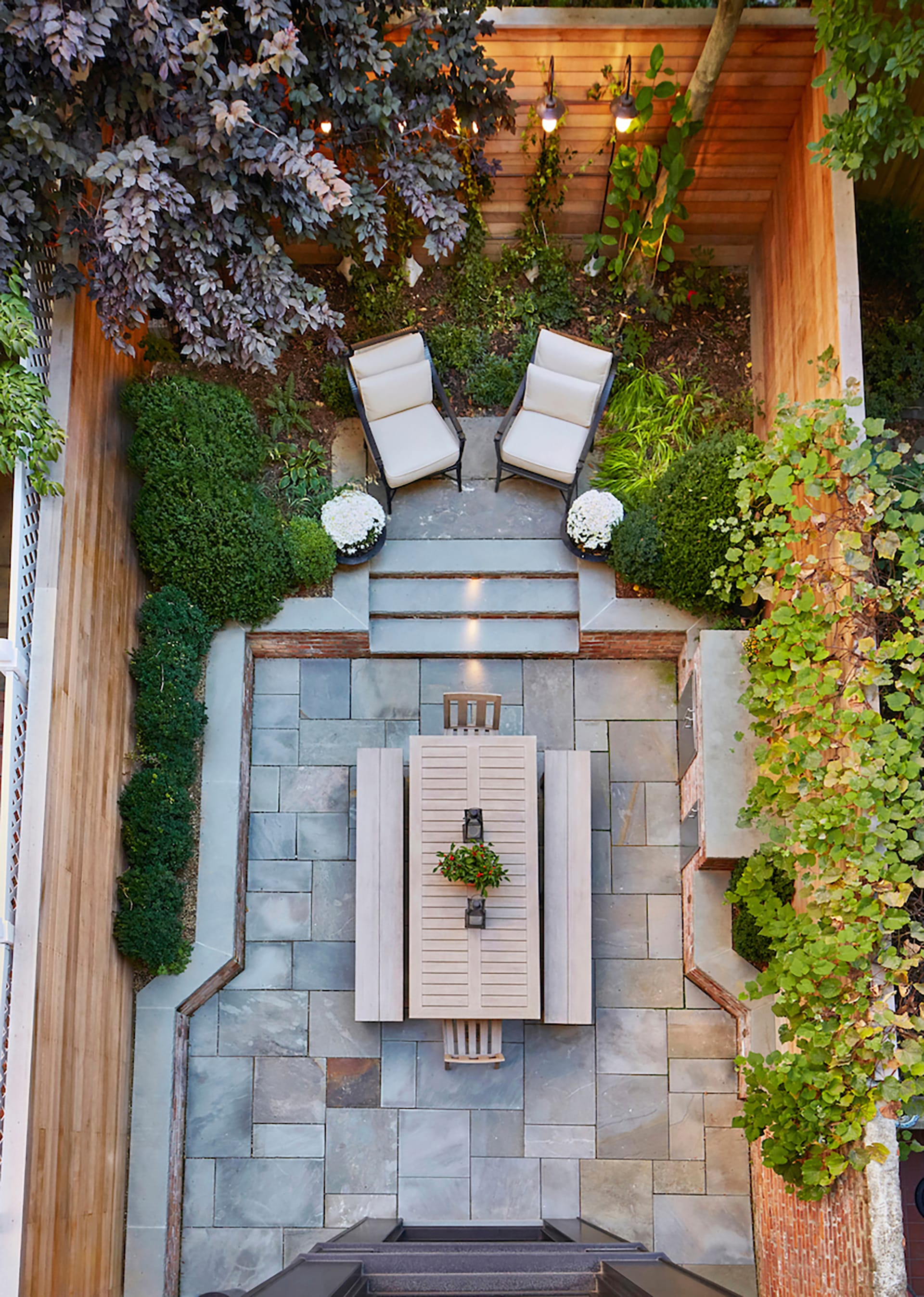 Bird's eye view of a rear yard with planters, a fire pit, and wood fence
