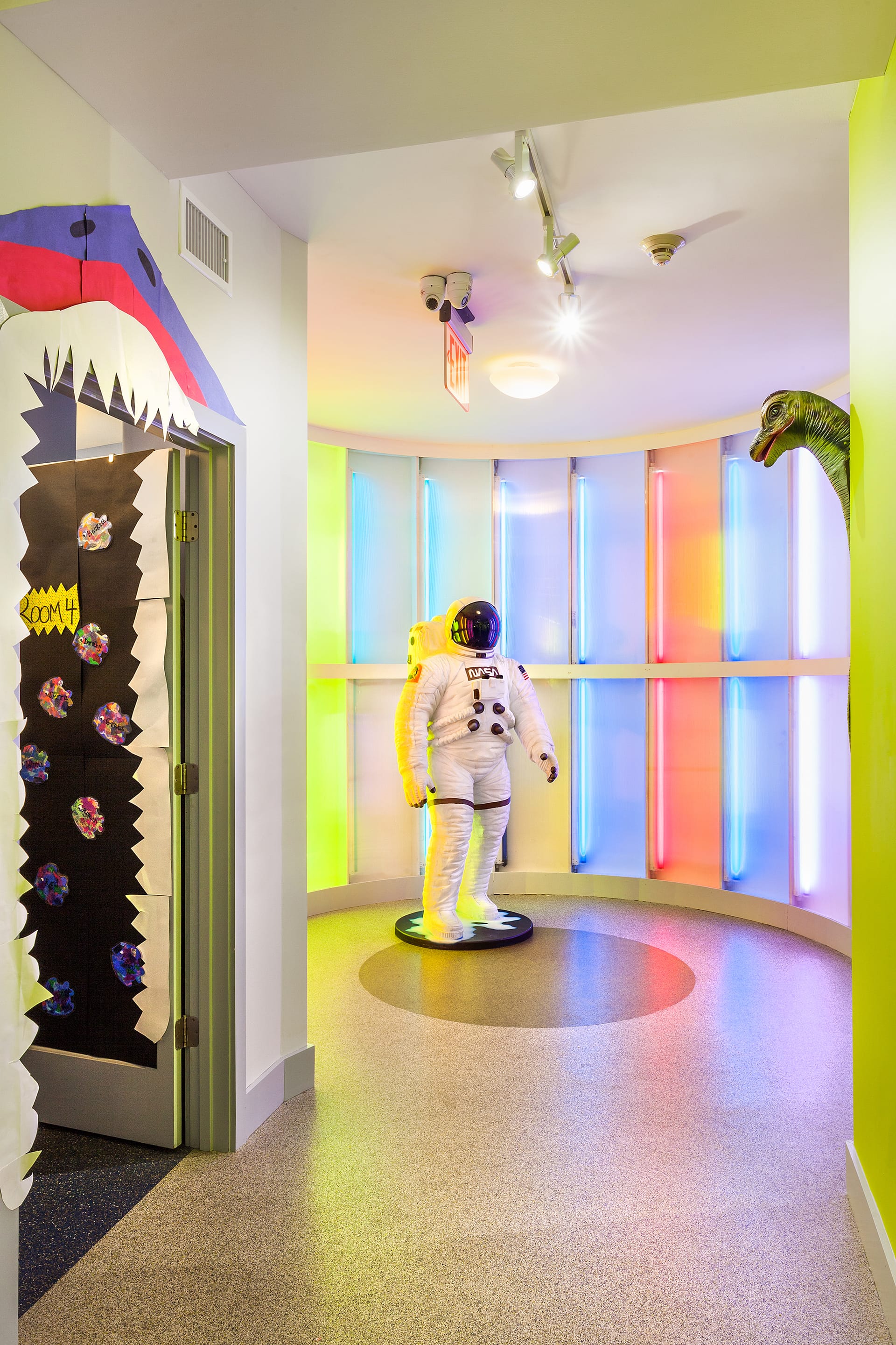 Rotunda with multicolored, paneled lighting and an astronaut suit in the middle