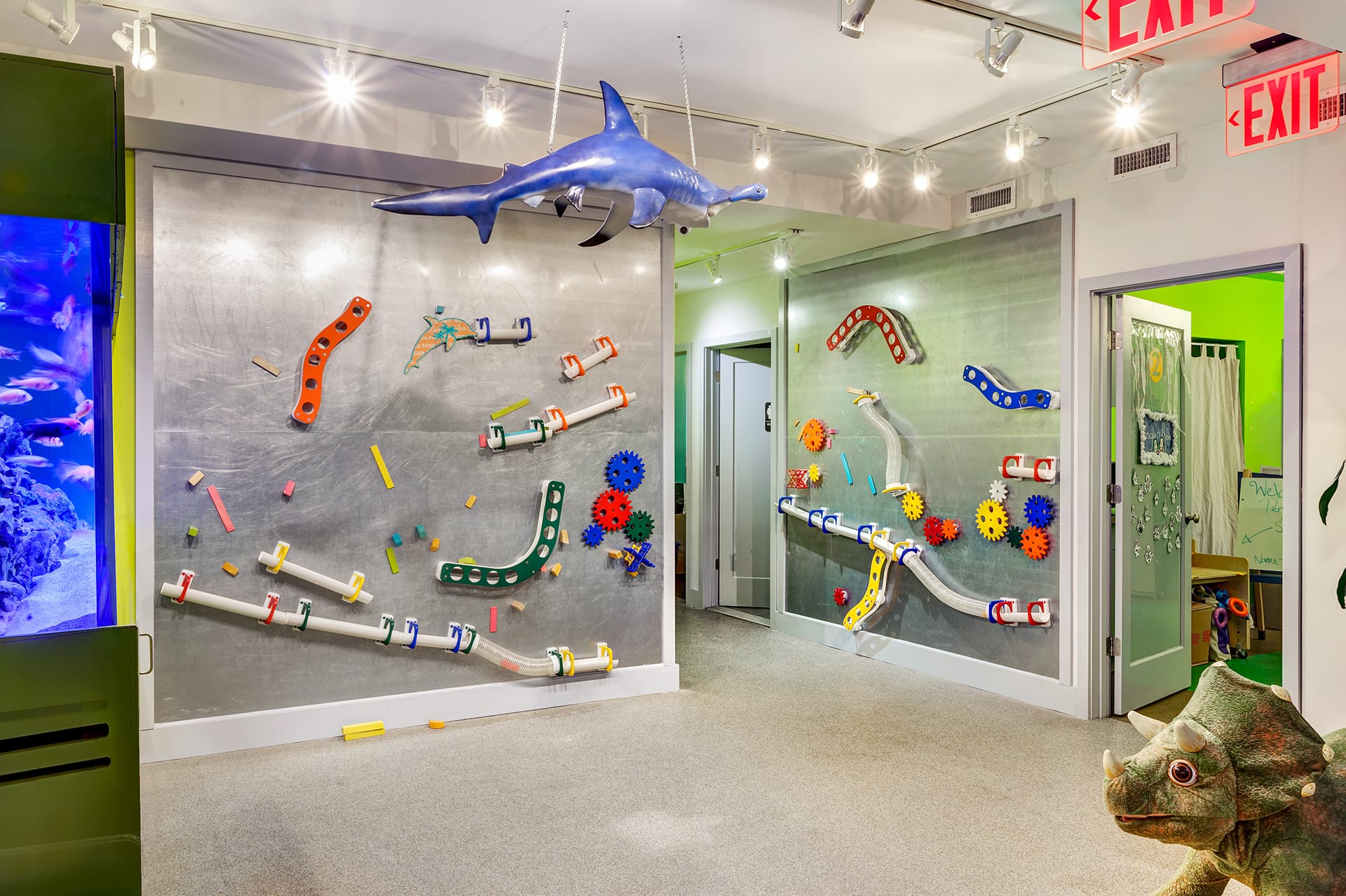 Hallway with magnetic walls, a hammerhead shark model hanging from the ceiling, and a dinosaur model.