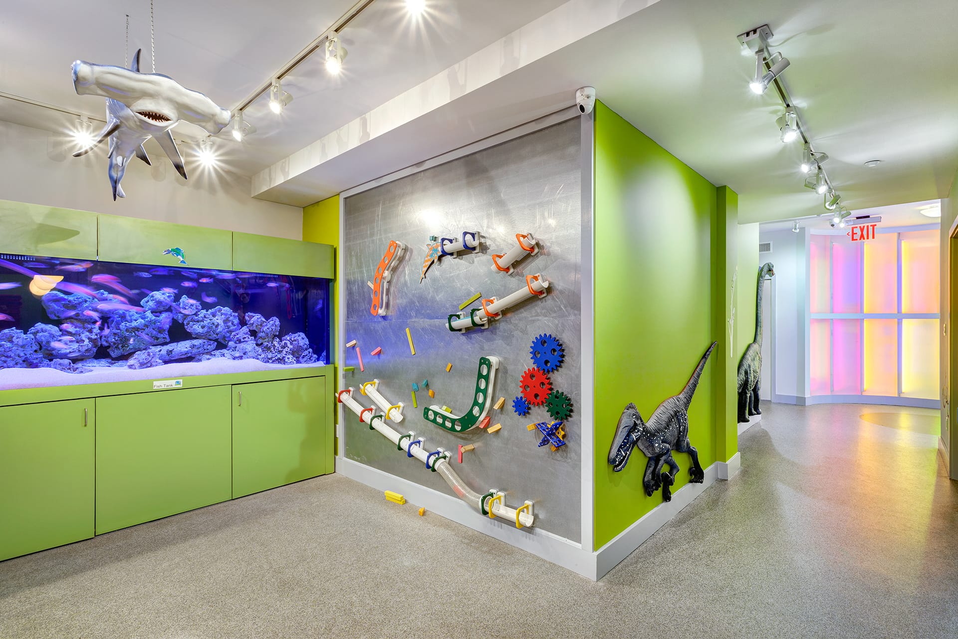 Hallway with magnetic walls, a hammerhead shark model hanging from the ceiling, and a large fish tank.