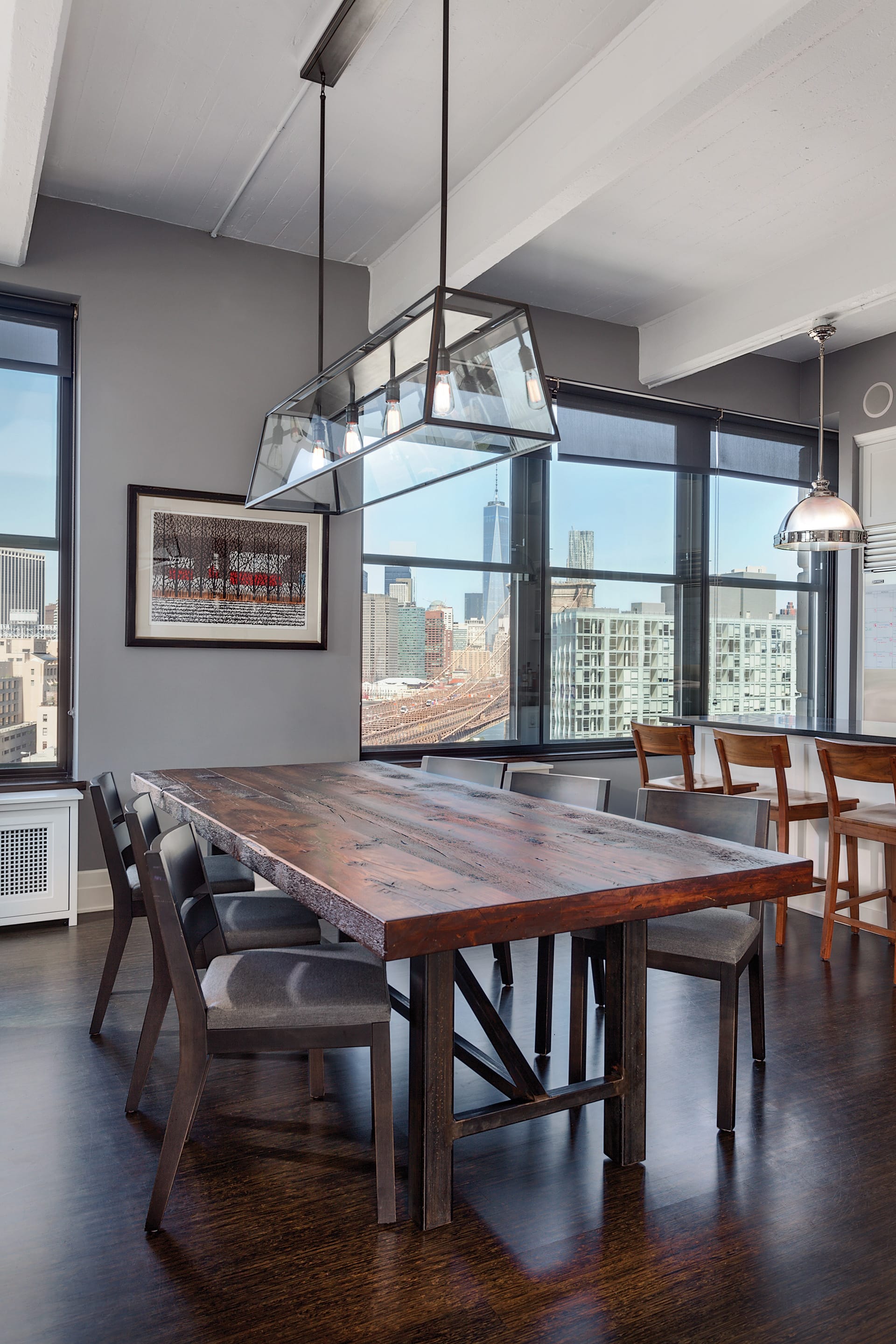 Dining area in a DUMBO loft with a wood dining table and decorative light fixture
