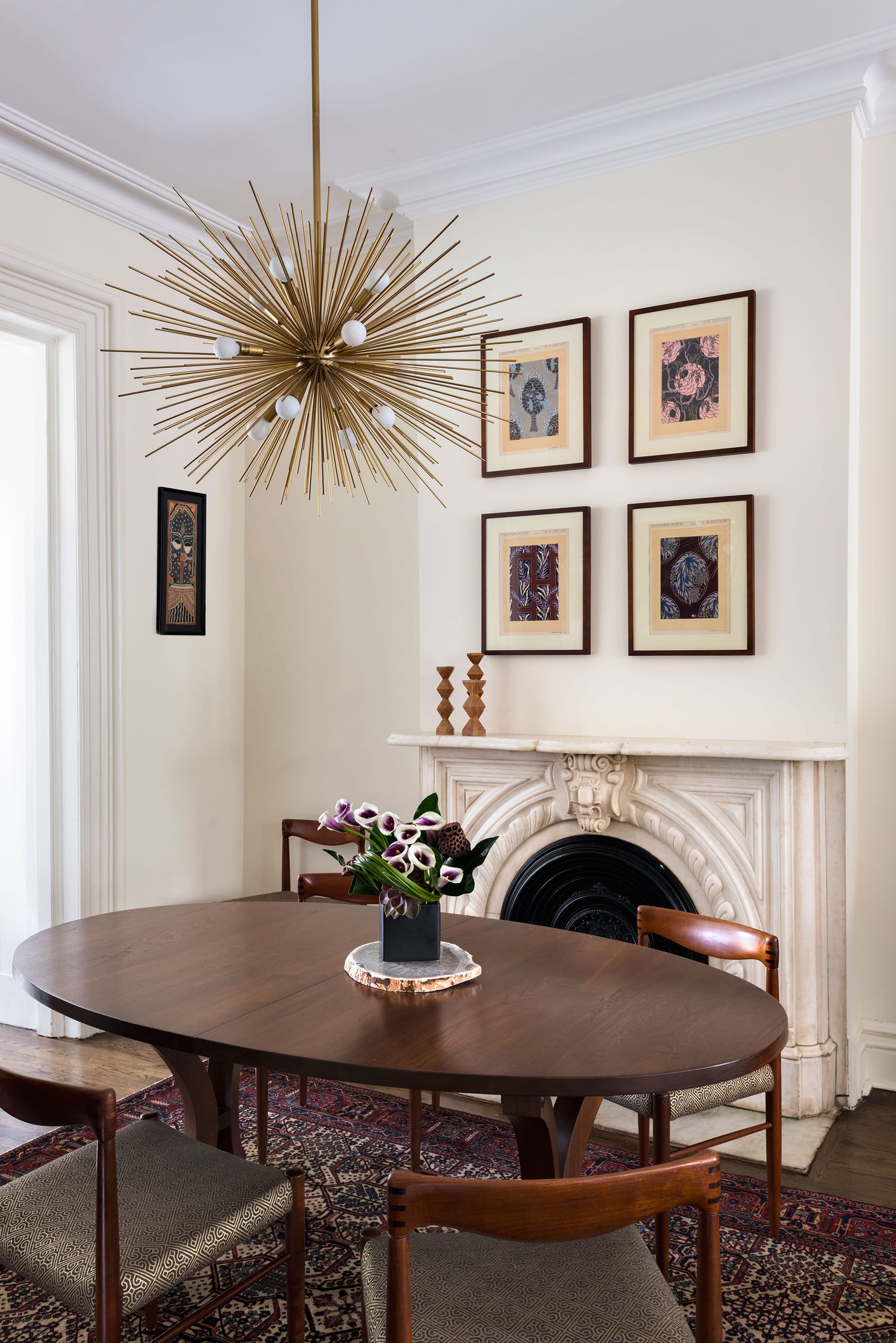 Dining room with a restored fireplace, statement chandelier, and dark wood table