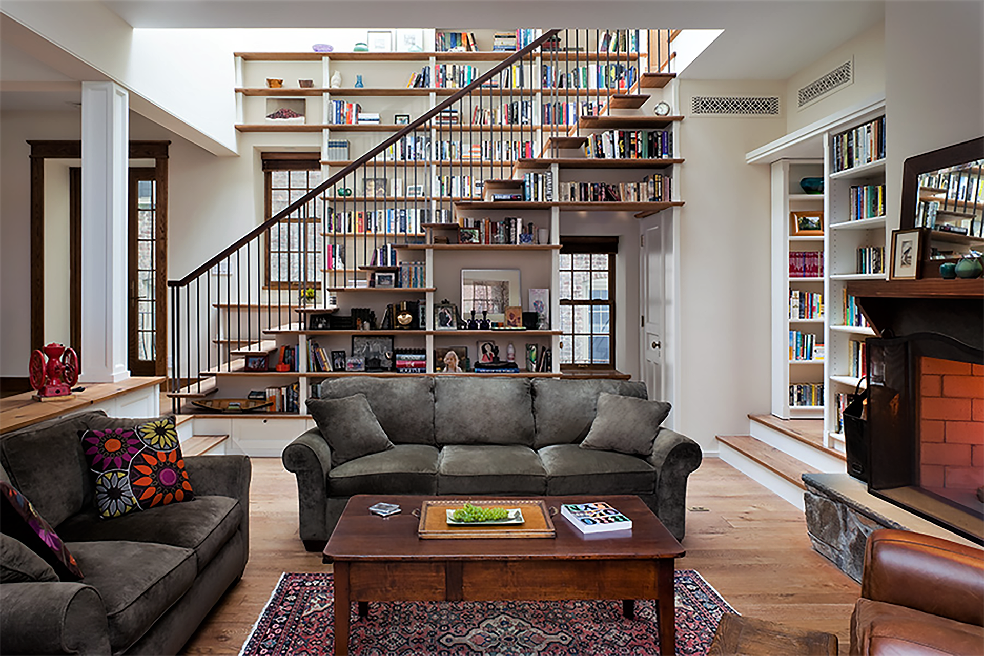 Living room of a Brooklyn Heights carriage house. The staircase leading to the second floor is lined with wood bookshelves on both sides.