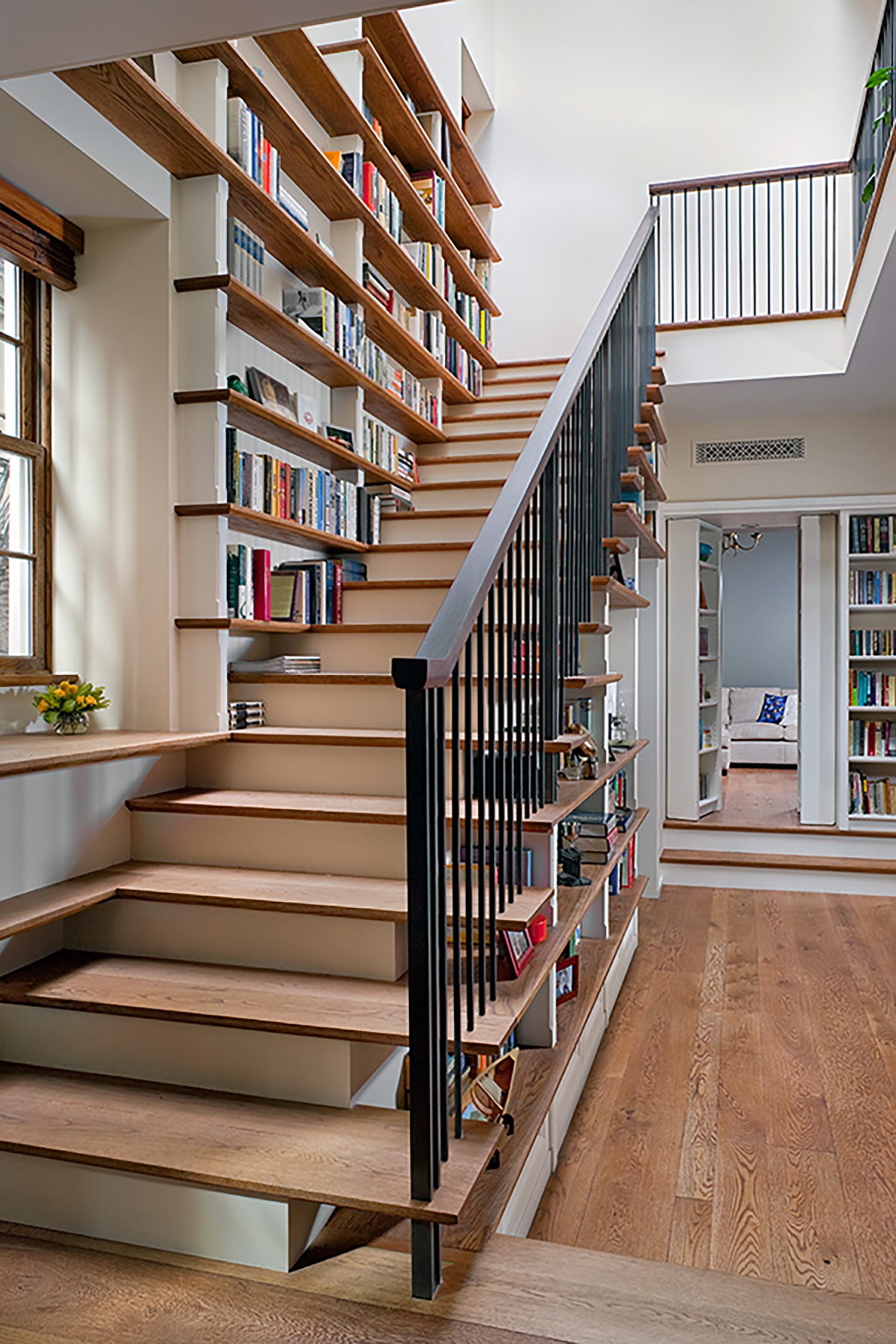 Staircase lined with bookshelves and metal balusters