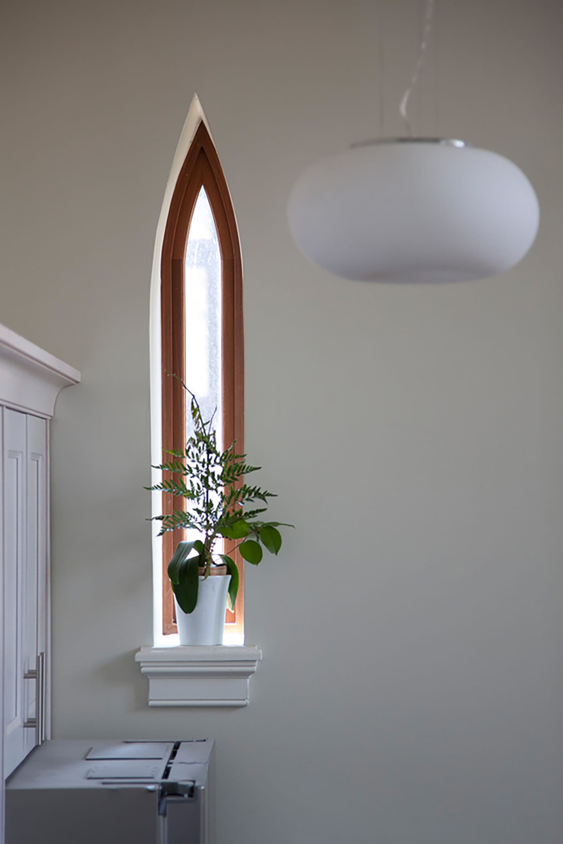 Pointed, narrow window with a houseplant on the window sill