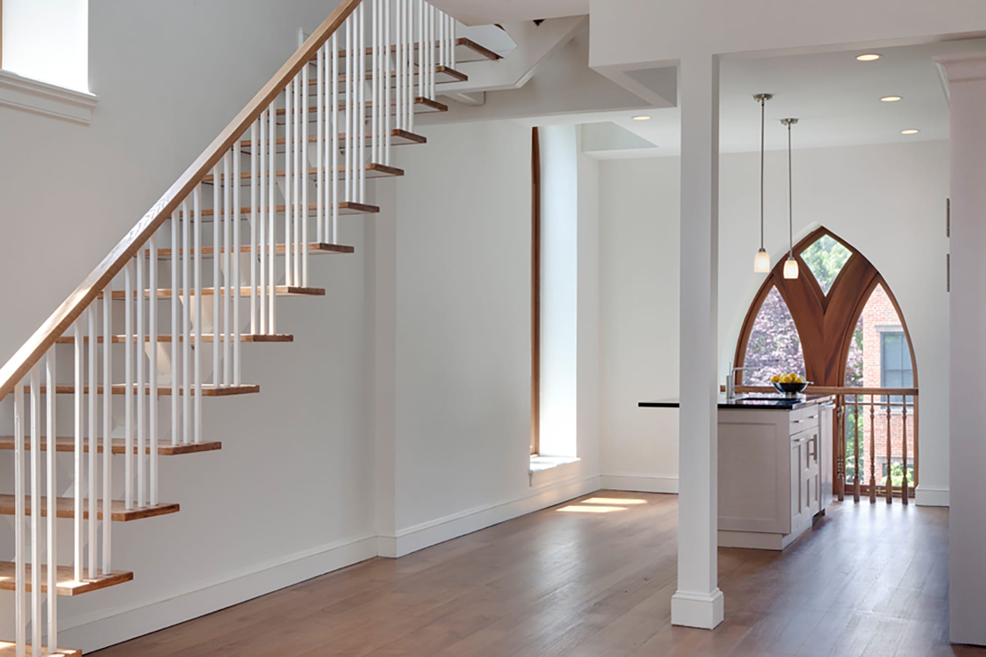 Kirchen with an open stringer, open riser staircase, restored windows, and white island in a Brooklyn condo