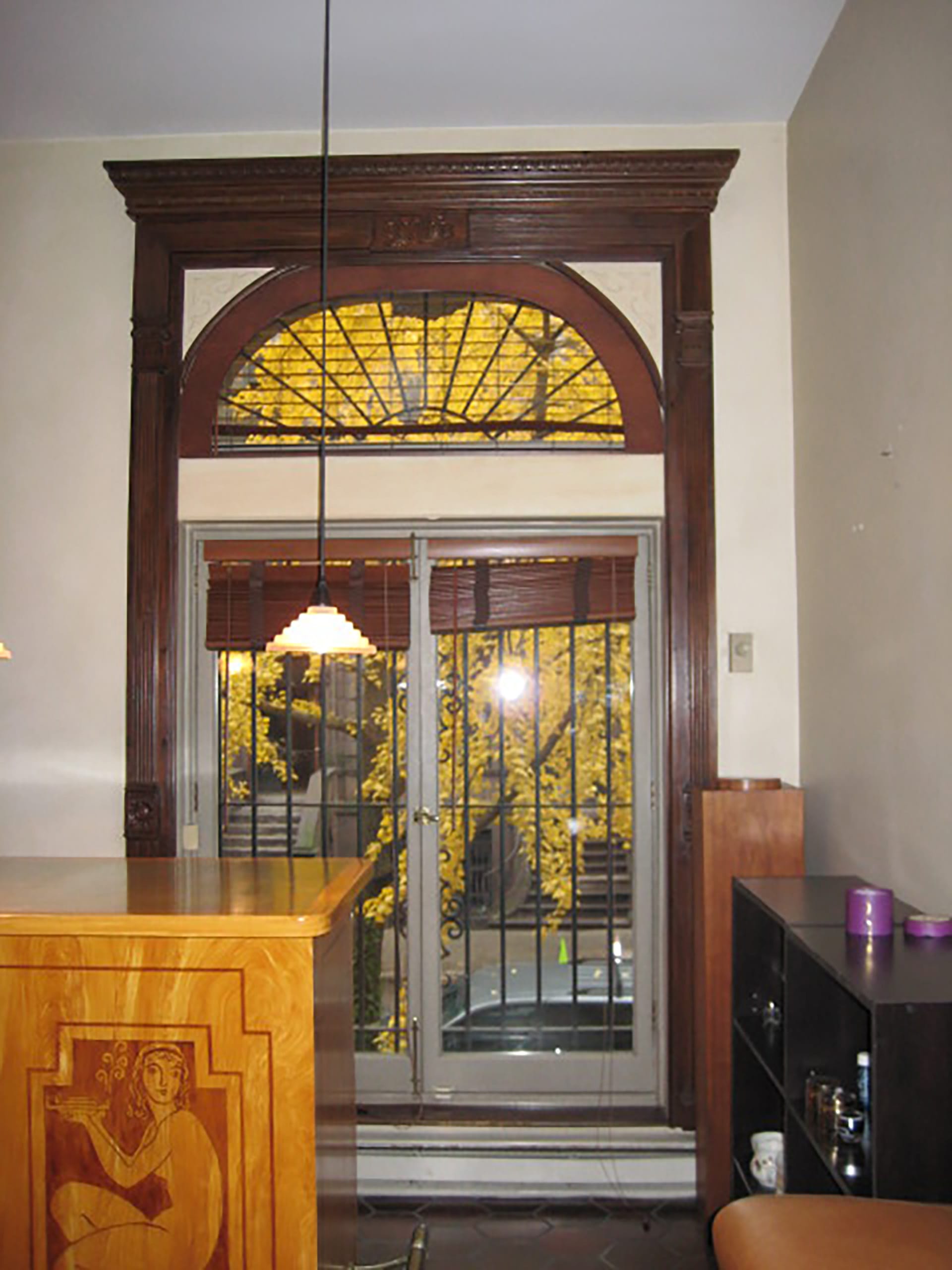 Entry door to a townhouse with dark wood detailing before our renovation