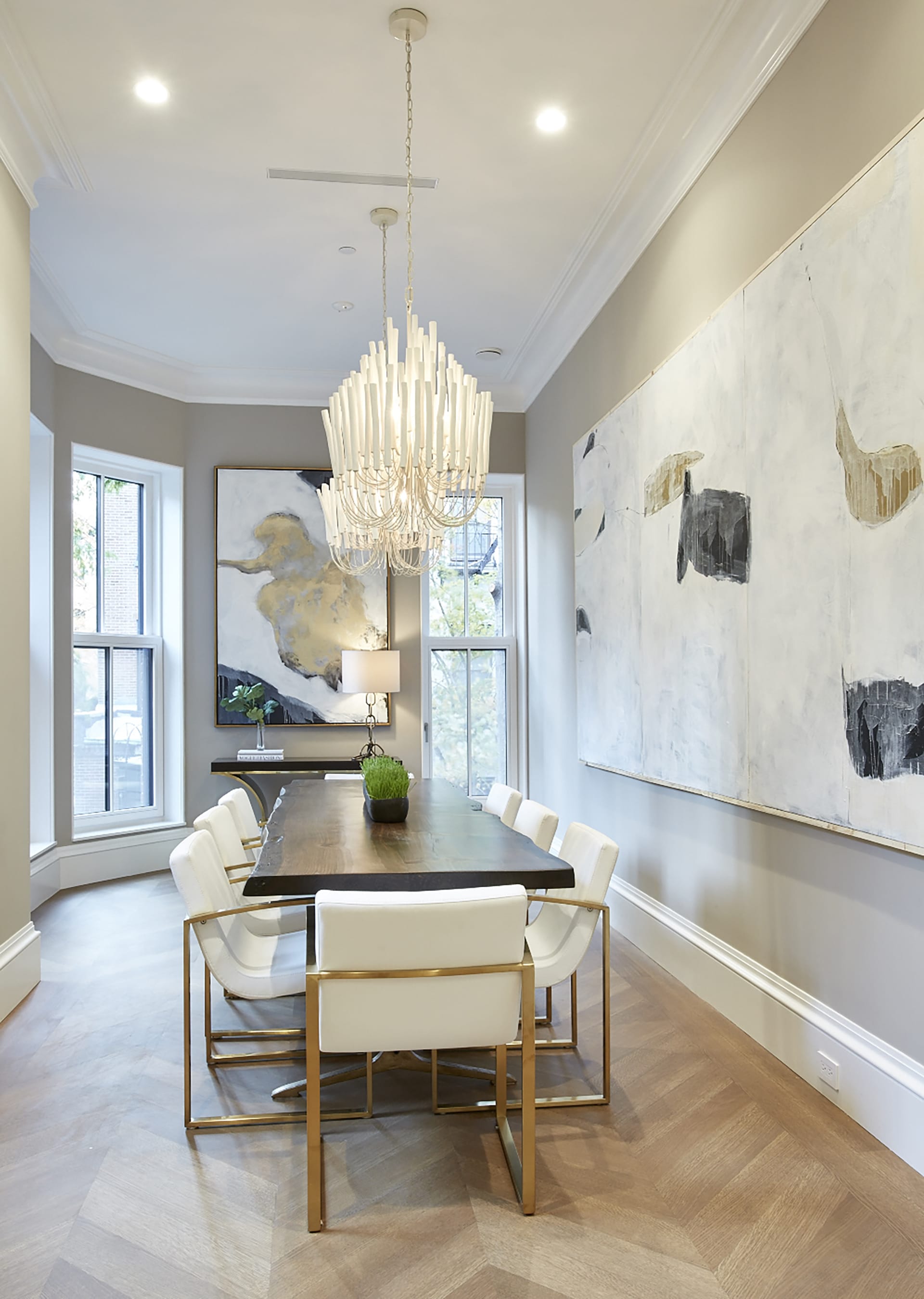 Dining room with two large chandeliers and two large paintings in a Brooklyn Heights Passive House